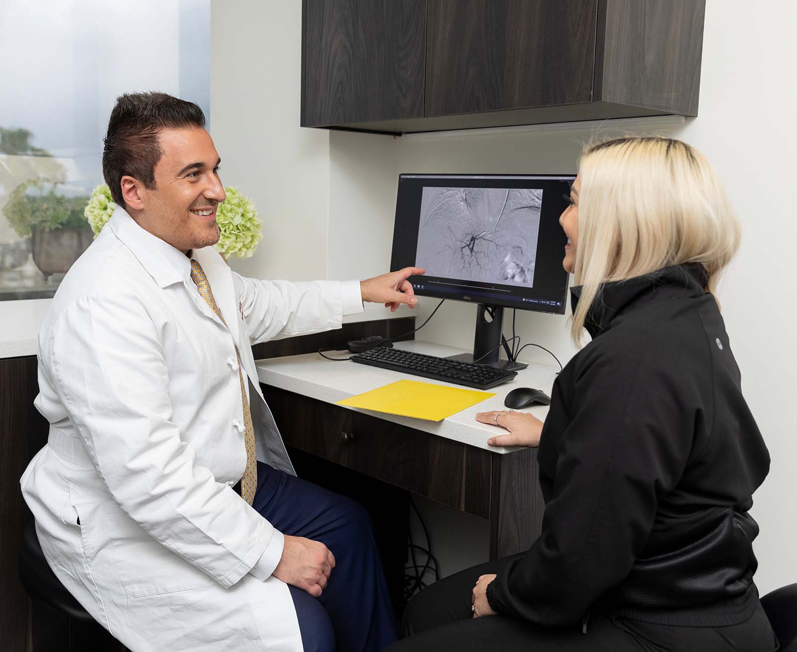 Dr. Navid Eghbalieh happily discussing the successful cancer treatment with patient at their Los Angeles office