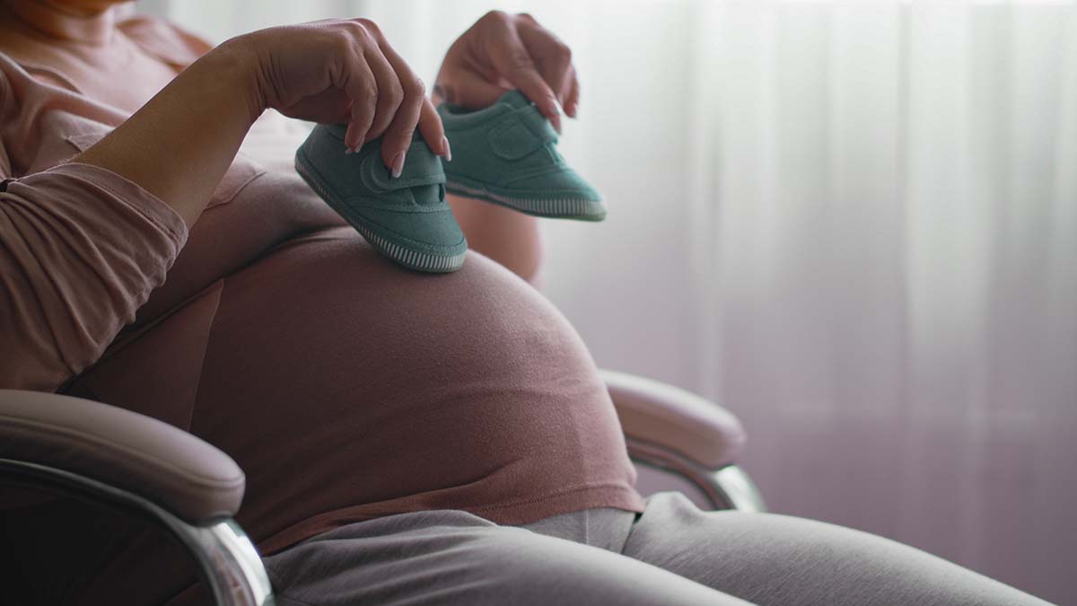 A pregnant woman sitting in a chair might need hernia treatment after giving birth