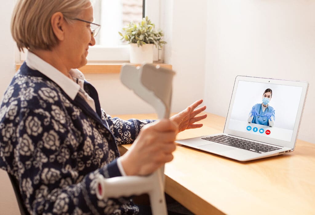 Senior woman using her laptop at home for a convenient video call with her doctor