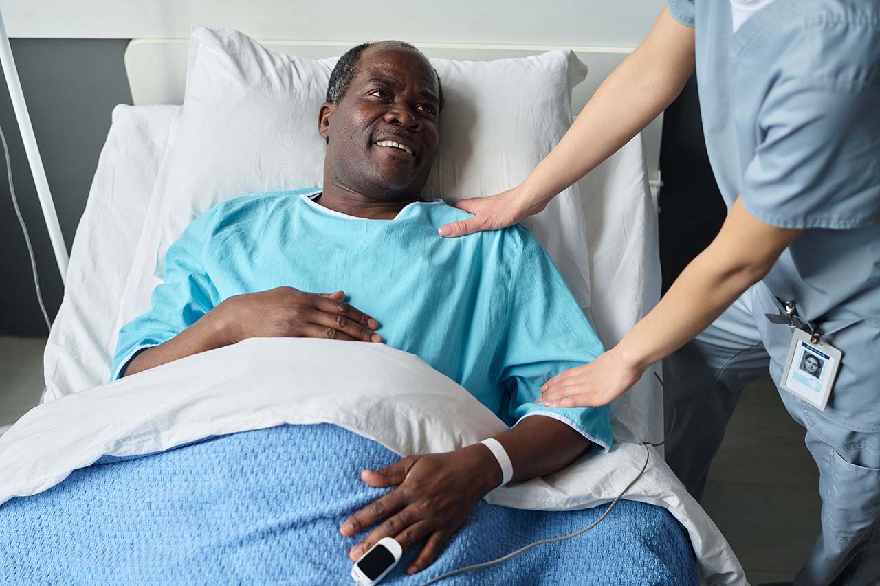 smiling senior patient talking to nurse following surgery