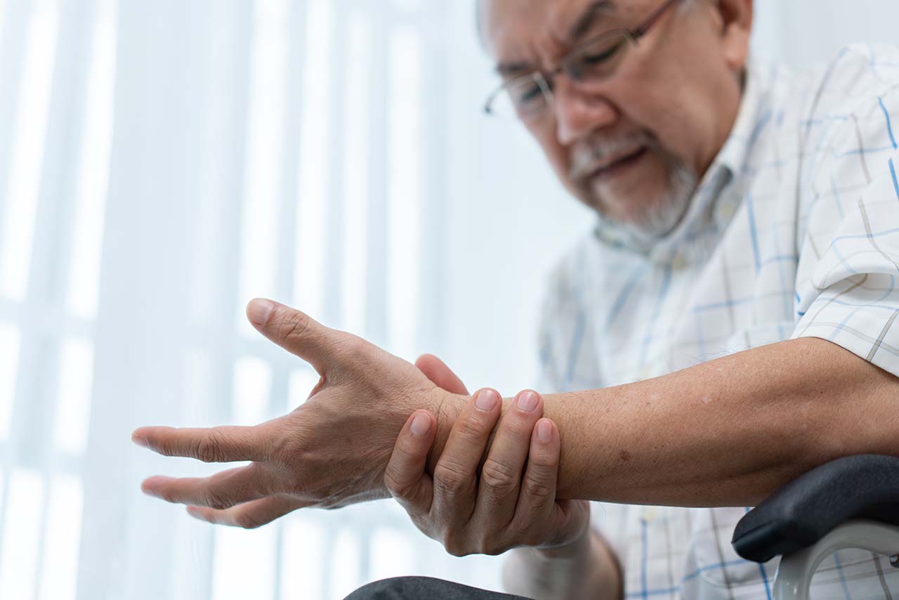 senior man massaging his wrist and hand due to pain