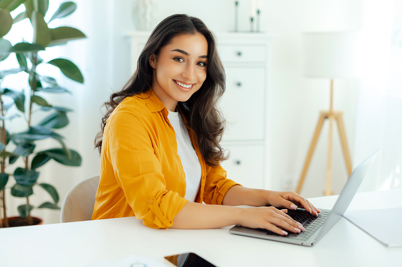 Young Spanish speaking woman works on her laptop