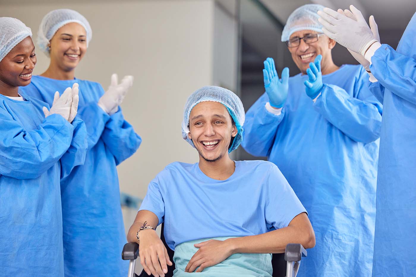 surgery patient in a wheelchair receives applause from doctors healthcare workers
