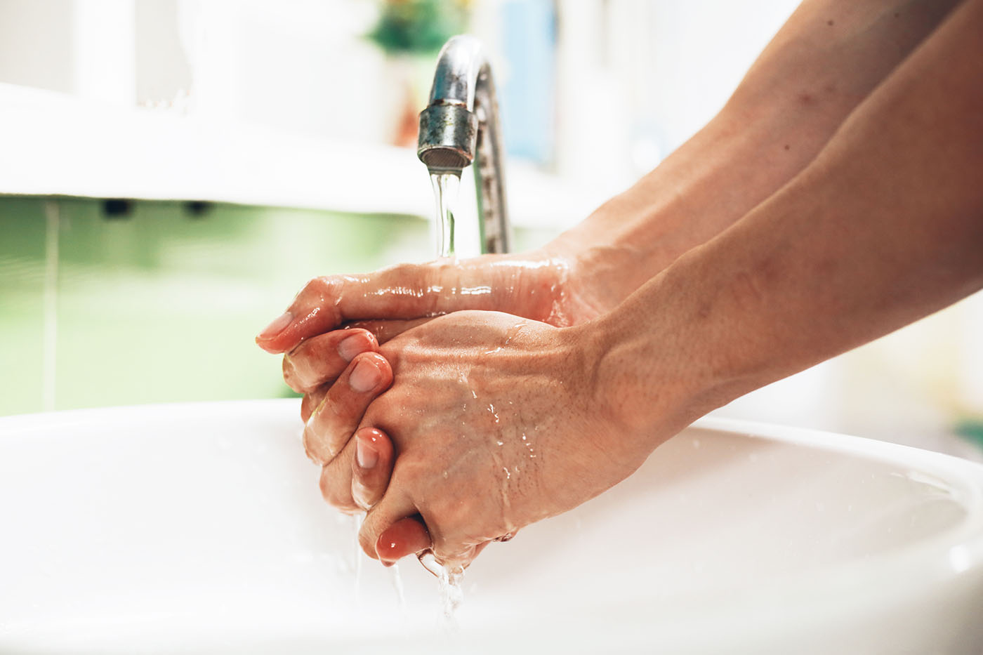 woman washes her hands in preparation of cleaning her surgical wound
